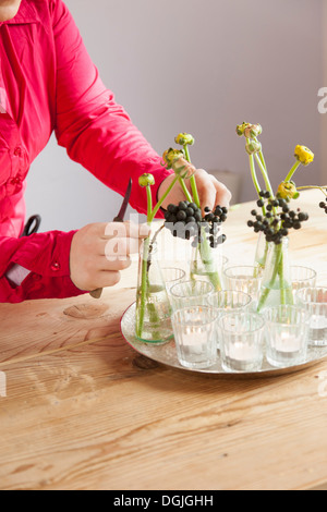 Close up of young woman arranging fresh flowers and plants Stock Photo