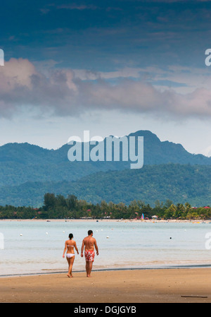 Two people walking along Pentai Tengah beach in Langkawi. Stock Photo