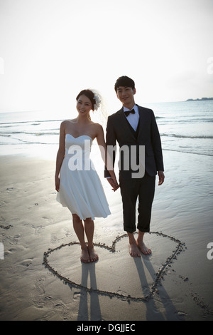 newlyweds walking on the beach Stock Photo