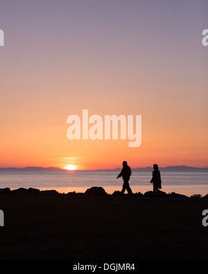 Couple enjoying a walk under the Midnight Sun, Seltjarnarnes, Reykjavik, Iceland Stock Photo