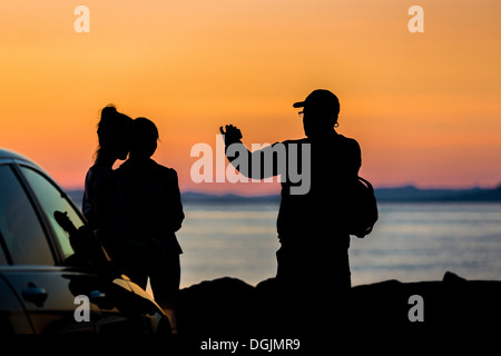Taking pictures with a smartphone under the Midnight Sun, Seltjarnarnes, Reykjavik, Iceland Stock Photo