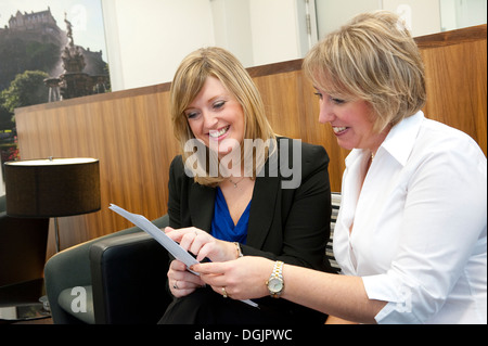 Two businesswoman reading through a document together. Stock Photo