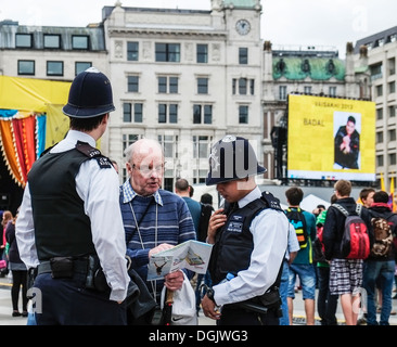 Two Metropolitan Police officers helping a tourist. Stock Photo