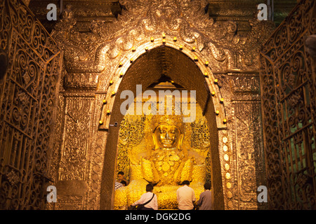 The famous gold leaf-encrusted Buddha in the Mahamuni Pagoda in Mandalay in Myanmar. Stock Photo