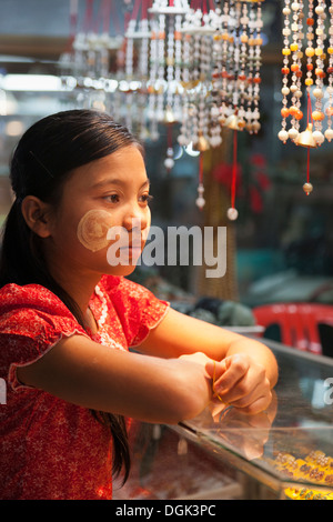 A young Burmese girl with Thanaka face decoration in Bogyoke (formerly Scott) Market  in Yangon in Myanmar. Stock Photo