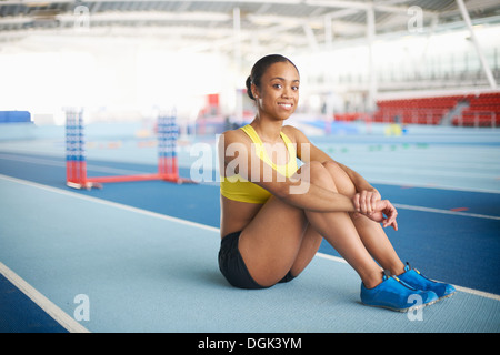 Young female athlete sitting on floor, portrait Stock Photo