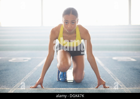 Young female athlete on starting blocks Stock Photo