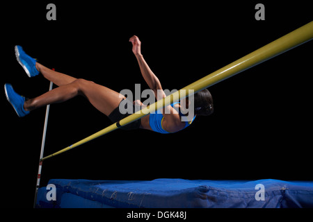 Young female athlete doing high jump Stock Photo