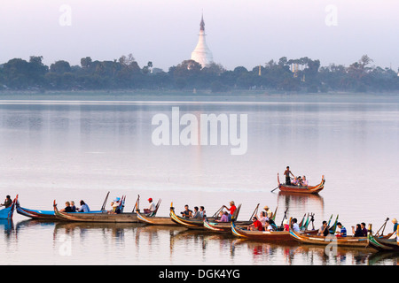 Tourist boats lining up on Taungthaman Lake in Myanmar to view sunset over U Bein Teak Bridge.