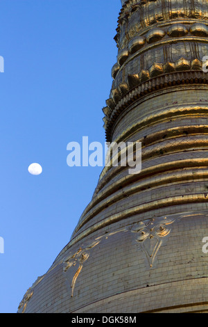 The moon rises over the main stupa of the Shwedagon Temple Complex in Yangon in Myanmar. Stock Photo