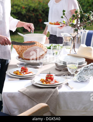Man carving christmas dinner in Australian sunlight Stock Photo
