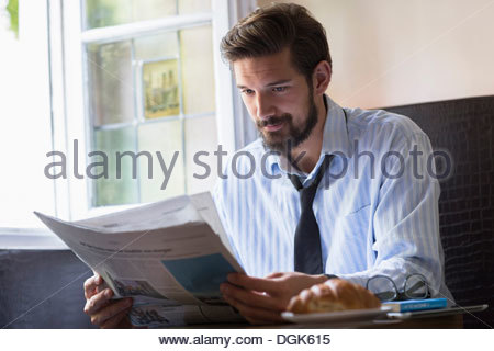 https://l450v.alamy.com/450v/dgk615/portrait-of-man-having-breakfast-and-reading-newspaper-dgk615.jpg