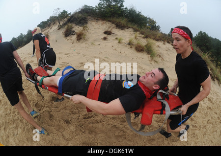 Naval aircrewmen assigned to Helicopter Mine Countermeasures Squadron (HM 14) compete in a CPR challenge where sailors have to carry a live body on a stretcher at the four-story Sand Mountain obstacle course. Nearly 100 pilots and naval aircrewmen from si Stock Photo