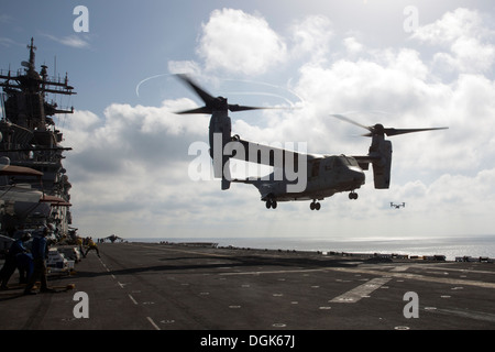 An MV-22 Osprey from Marine Medium Tiltrotor Squadron (VMM) 266 (Reinforced) lands on the flight deck of the amphibious assault Stock Photo