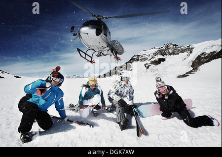 Group of skiers with rescue helicopter overhead Stock Photo