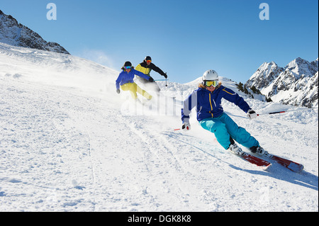 Three skiers going downhill Stock Photo
