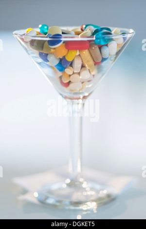 Studio shot of colorful pills in martini glass Stock Photo