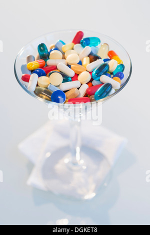 Studio shot of colorful pills in martini glass Stock Photo