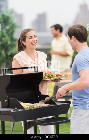 Friends enjoying barbecue in garden Stock Photo