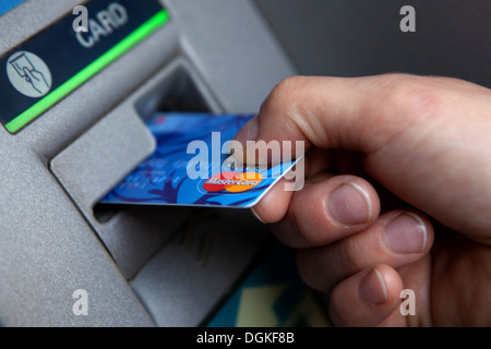 Insert credit card into an ATM machine cash bank teller Stock 