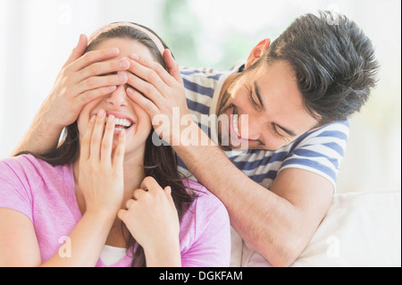 Man covering woman's eyes with his hands Stock Photo