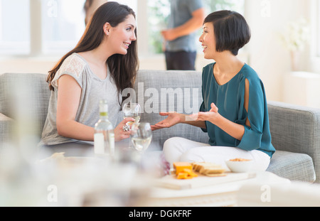Two friends sitting on sofa and talking Stock Photo