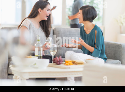 Two friends sitting on sofa and talking Stock Photo