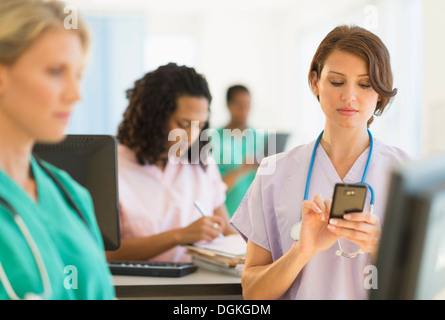 Doctors and nurses working at desks in hospital Stock Photo