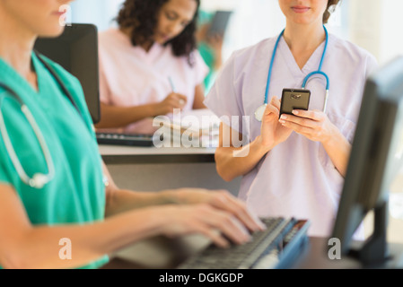 Doctors and nurses working at desks in hospital Stock Photo