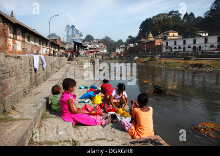 Girls washing clothes in the Bagmati River. Stock Photo