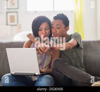Young woman and young man using laptop Stock Photo