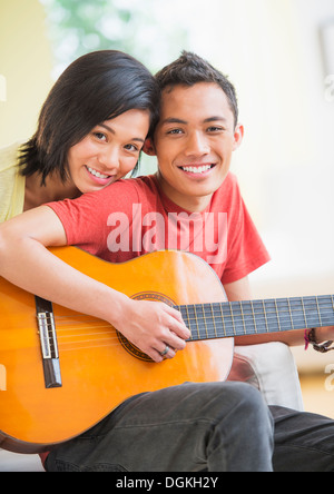Portrait of young couple, man holding guitar Stock Photo