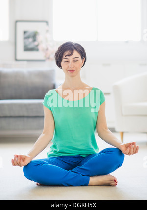 Young woman meditating at home Stock Photo - Alamy