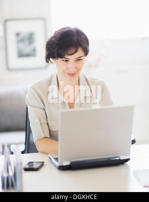 Woman working on laptop at home office Stock Photo