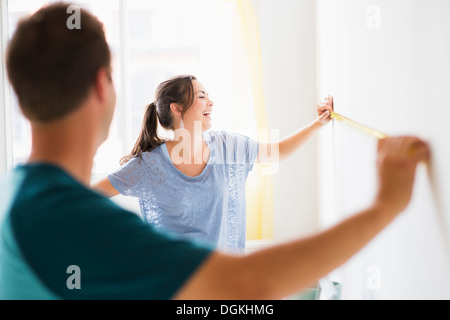 Couple measuring wall Stock Photo