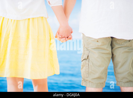 Studio Shot Mid section of couple standing and holding hands Stock Photo