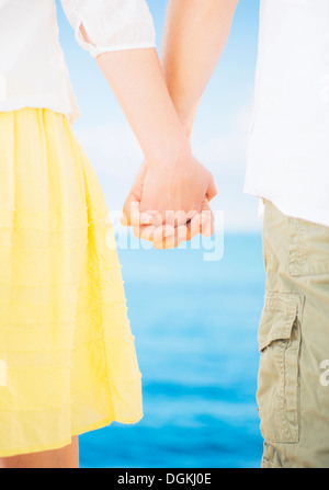 Studio Shot Mid section of couple standing and holding hands Stock Photo