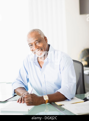 Portrait of senior man writing in office Stock Photo