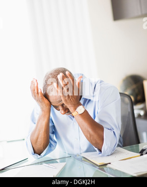 Portrait of tired senior man in office Stock Photo
