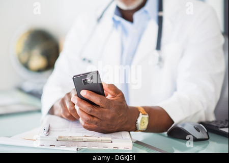 Close up of doctor's hand holding mobile phone Stock Photo