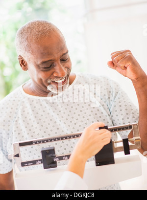 Happy man on weight scale Stock Photo