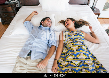 Young couple lying on bad in hotel room Stock Photo