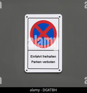 Sign "Einfahrt freihalten, Parken verboten", German for "keep clear, no parking", on a grey wall, PublicGround Stock Photo