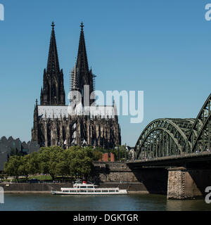 View as seen from Deutz across the Rhine river, Hohenzollernbruecke bridge, Willi Ostermann excursion boat in the foreground Stock Photo
