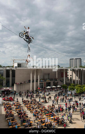 Museum Mile Festival, high-wire artist Falko Traber riding a motorbike on the tightrope, audience below, Bonn Stock Photo