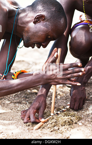 SAMBURU, KENYA - NOVEMBER 8: portrait of an African tribal man making fire in traditional way on November 8, 2008 Stock Photo