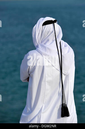 Qatari in traditional clothing with gutra, in front of Khor Al Udeid Beach, Khor El Deid, Inland Sea, desert miracle of Qatar Stock Photo