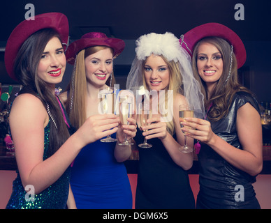 Attractive friends clinking champagne glasses at hen night Stock Photo