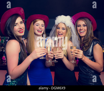 Laughing friends clinking champagne glasses at a hen night Stock Photo