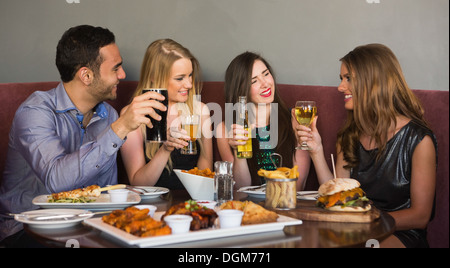 Happy friends sitting together having dinner Stock Photo